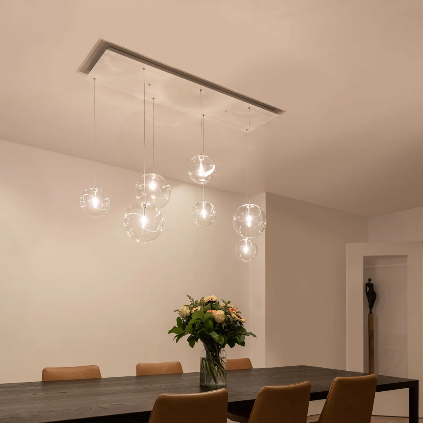 Novi 7 hanglamp met witte plafondplaat en zeven glazen bollen.
