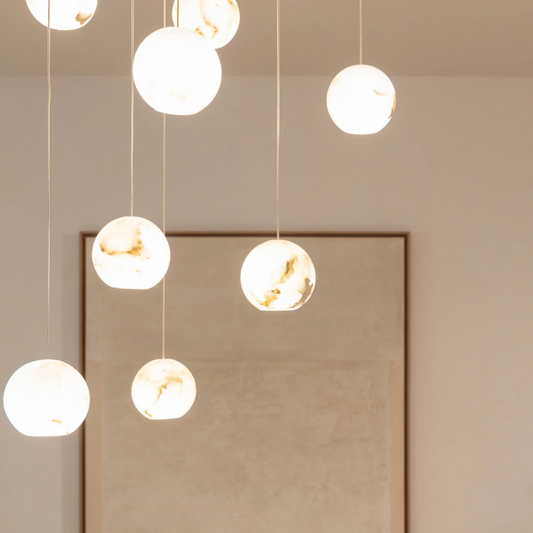 Noor hanglamp met alabaster bollen en witte plafondplaat in hoge entree sfeer